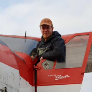 Joel Strong-Covello is standing on a float plane